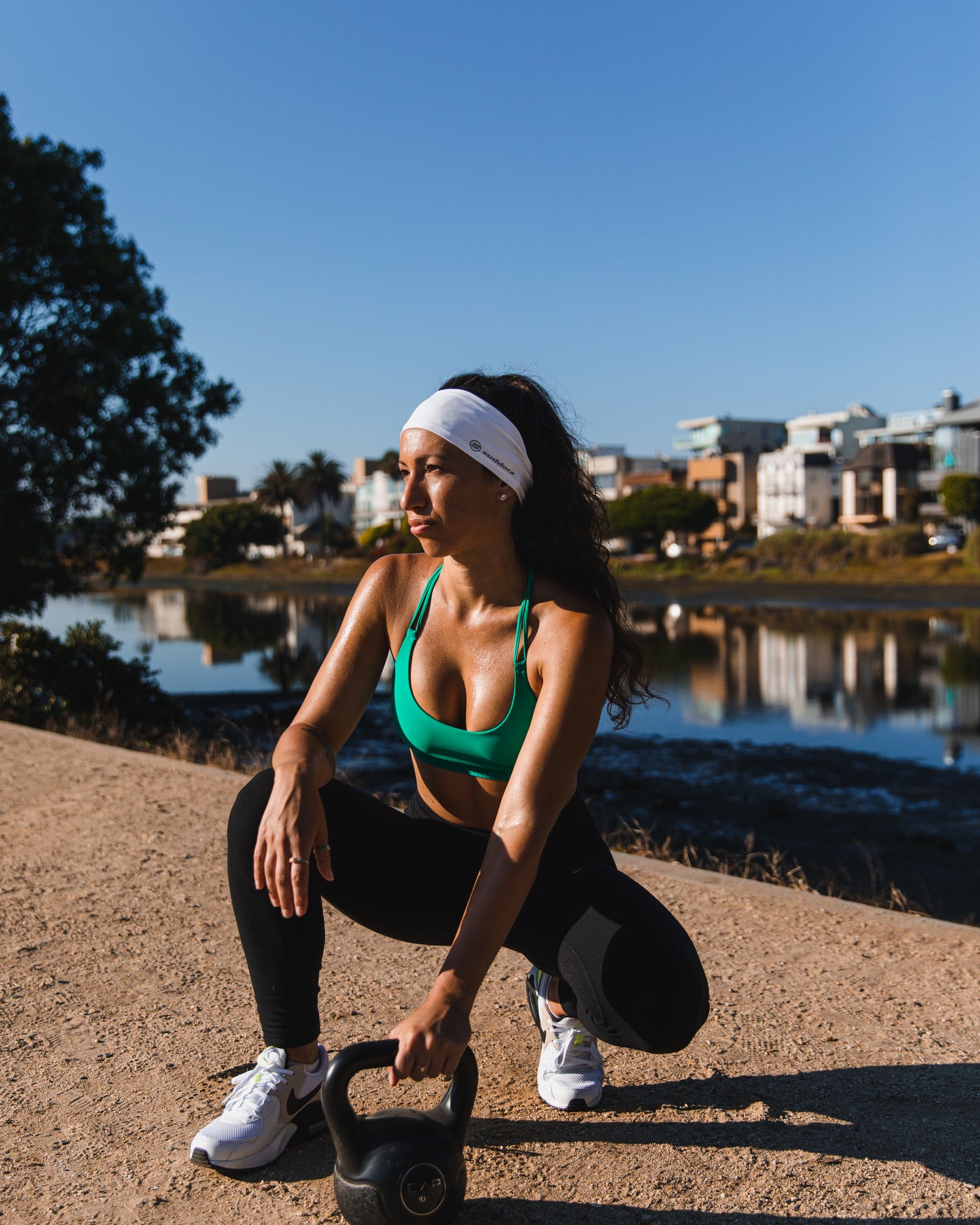 Women doing kettlebell exercise wearing Suddora headband 